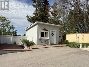 Bradford West Gwillimbury apartment for rent - A small white house with a patio and a white fence.