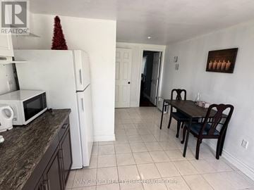 Bradford West Gwillimbury apartment for rent - A kitchen with a white fridge and a table with chairs.