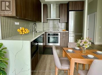 Toronto (Mimico) condo for rent - A kitchen with a table and chairs in front of it.