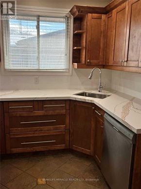 St. Catharines (Vine/Linwell) apartment for rent - A kitchen with wooden cabinets and a marble countertop.