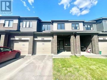 Ottawa townhouse for rent - A red car is parked in front of a house with a garage.