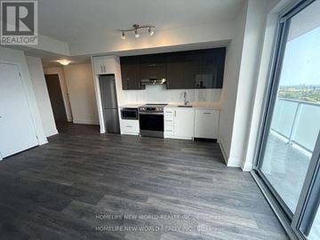Toronto (Don Valley Village) condo for rent - A spacious kitchen with white cabinets and a dark countertop.