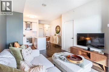 Burlington condo for rent - A living room with a white couch and a television on a wooden stand.