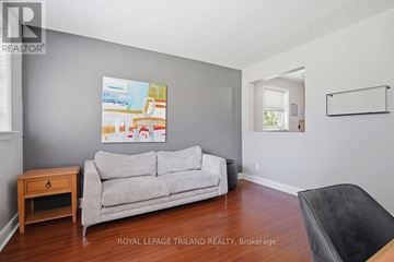 London South (South F) multi-family for rent - A living room with a grey couch and a painting on the wall.