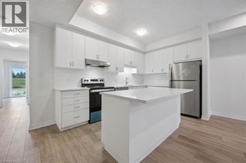 Kitchener townhouse for rent - A modern kitchen with white cabinets and a wooden floor.