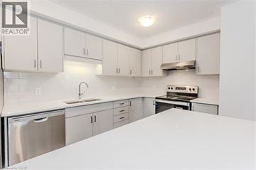 Kitchener townhouse for rent - A kitchen with white cabinets and appliances.
