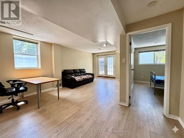 Toronto (Pleasant View) apartment for rent - A spacious living room with a black couch and a wooden table.