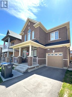 Brampton (Sandringham-Wellington North) apartment for rent - A house with a brown brick exterior and a tan garage door.