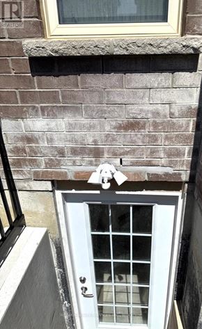 Brampton (Sandringham-Wellington North) apartment for rent - A white door with a glass window is set in a brick wall.