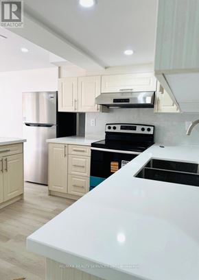 Brampton (Sandringham-Wellington North) apartment for rent - A kitchen with white appliances and cabinets.