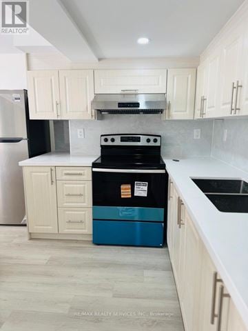 Brampton (Sandringham-Wellington North) apartment for rent - A kitchen with a black stove top oven and a blue dishwasher.
