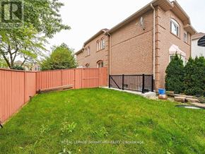 Mississauga (Central Erin Mills) apartment for rent - A red brick house with a black gate and a green lawn.