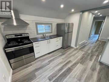 Hamilton (Stipley) duplex for rent - A modern kitchen with a stove top oven, sink, and refrigerator.