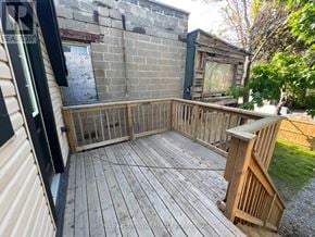 Hamilton (Stipley) duplex for rent - A wooden deck with a brick wall and a window.