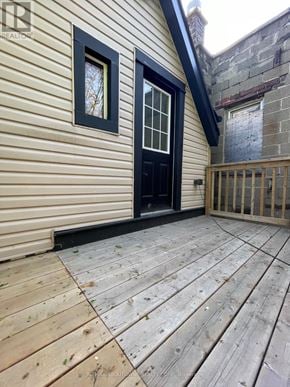 Hamilton (Stipley) duplex for rent - A wooden deck with a black door and a window.