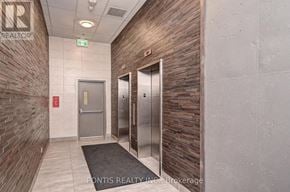Waterloo condo for rent - A hallway with a brick wall and two elevators.