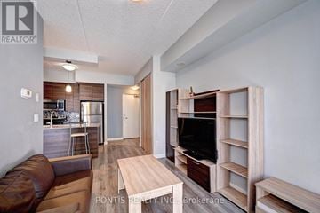 Waterloo condo for rent - A living room with a brown leather couch and a wooden entertainment center.