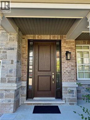 Niagara-On-The-Lake townhouse for rent - A brown door is on a stone and brick house.