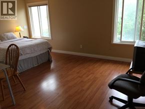 Richmond apartment for rent - A bedroom with a bed, chair, and window.
