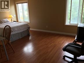 Richmond apartment for rent - A bedroom with a bed, chair, and window.