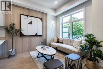 Vancouver townhouse for rent - A living room with a white couch, a coffee table, and a large abstract painting on the wall.