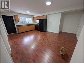 Richmond apartment for rent - A dog is standing in a kitchen with wooden floors and white walls.