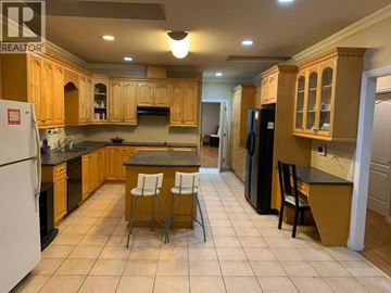 Richmond apartment for rent - A kitchen with wooden cabinets and a black refrigerator.