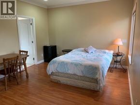 Richmond apartment for rent - A bedroom with a bed, chair, and table.