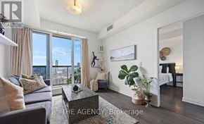 Toronto (Regent Park) condo for rent - A living room with a couch, a coffee table, and a large window overlooking the city.