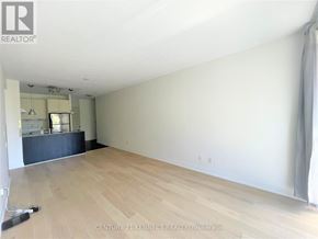 Toronto (Church-Yonge Corridor) condo for rent - A room with wooden flooring and a large window with a view of a kitchen.
