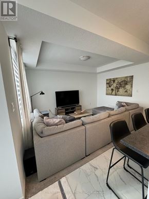 London North (North I) townhouse for rent - A living room with a grey couch and a television.