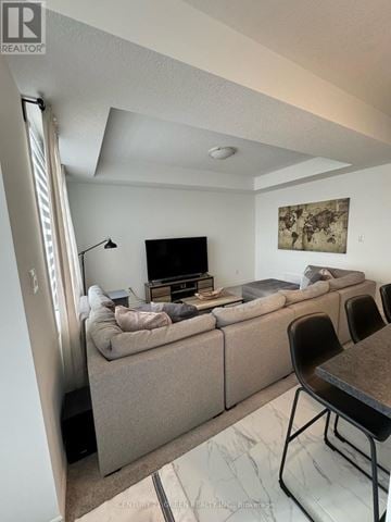 London North (North I) townhouse for rent - A living room with a grey couch and a television.