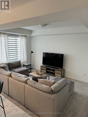 London North (North I) townhouse for rent - A living room with a large couch and a television on a stand.