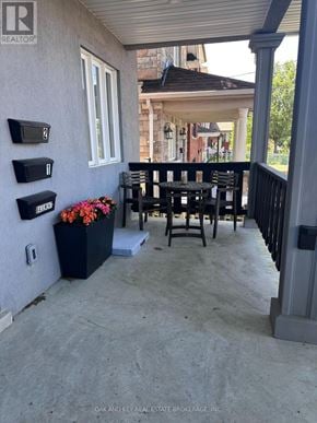 Toronto (Rockcliffe-Smythe) duplex for rent - A patio with a table and chairs and mailboxes on the wall.