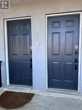 Toronto (Rockcliffe-Smythe) duplex for rent - A pair of dark blue double doors with numbers 2 and 1 on them.