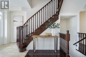 Collingwood apartment for rent - A staircase with a wooden banister and a table with a vase on it.