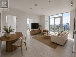 Hamilton (Corktown) condo for rent - A living room with a television, couch, and chairs.