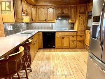 West Grey apartment for rent - A kitchen with wooden cabinets and a black dishwasher.