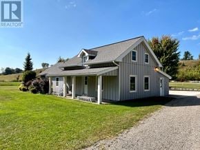 West Grey apartment for rent - A house with a grey roof and white walls is surrounded by a gravel driveway.