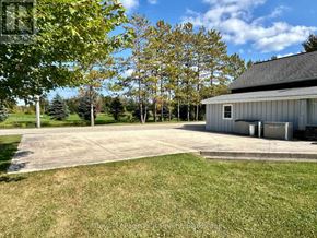 West Grey apartment for rent - A large, open yard with a building and trees in the background.