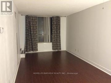 Markham (Commerce Valley) condo for rent - A room with a wooden floor and a window with curtains.