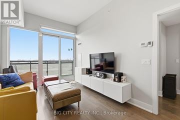 Markham (Unionville) condo for rent - A living room with a yellow couch and a flat screen TV mounted on the wall.