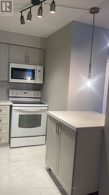 Mississauga (Hurontario) condo for rent - A kitchen with a white oven and microwave.