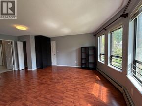 Vancouver apartment for rent - A room with wooden floors and a large window on the right side.