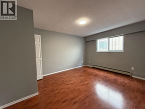 Vancouver apartment for rent - A room with wooden flooring and a window with blinds.