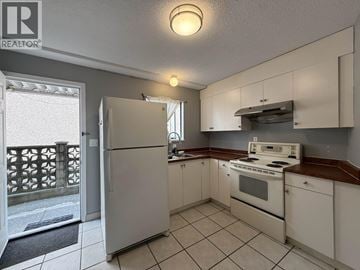 Vancouver apartment for rent - A kitchen with white cabinets and a stove top oven.