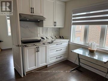 Markham (Cornell) apartment for rent - A kitchen with white cabinets and a marble island.