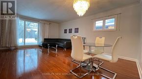Richmond Hill (Crosby) apartment for rent - A living room with a black couch, a glass table, and a chandelier.