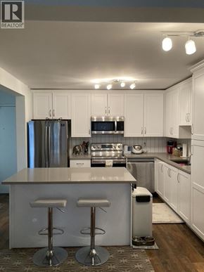Coquitlam apartment for rent - A modern kitchen with white cabinets and a central island.