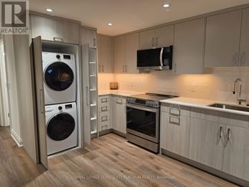 Toronto (Trinity-Bellwoods) apartment for rent - A modern kitchen with a washing machine and oven built into the cabinetry.